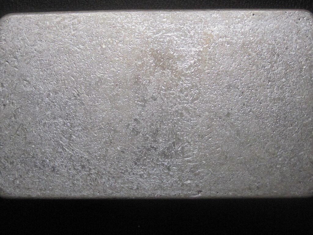 Close-up of a cast silver bar with dips, ripples, and satin frost finish from Scottsdale Silver