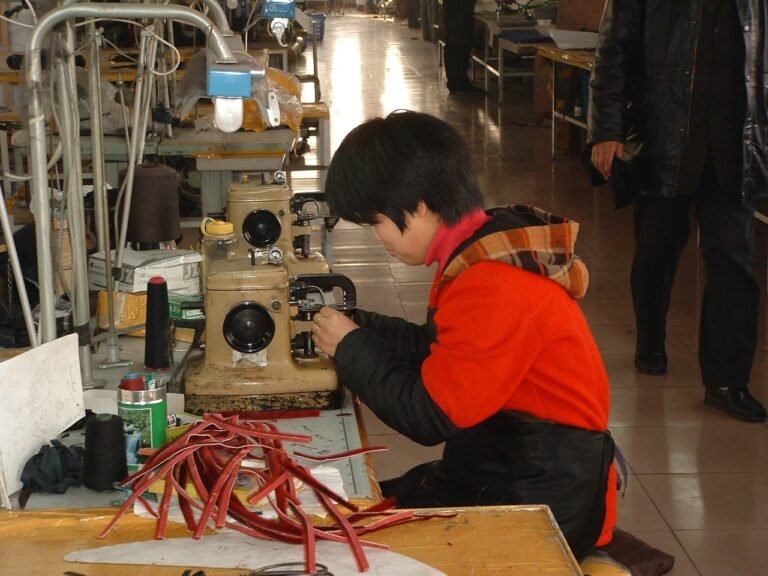 Chinese factory workers assembling leather products on production line